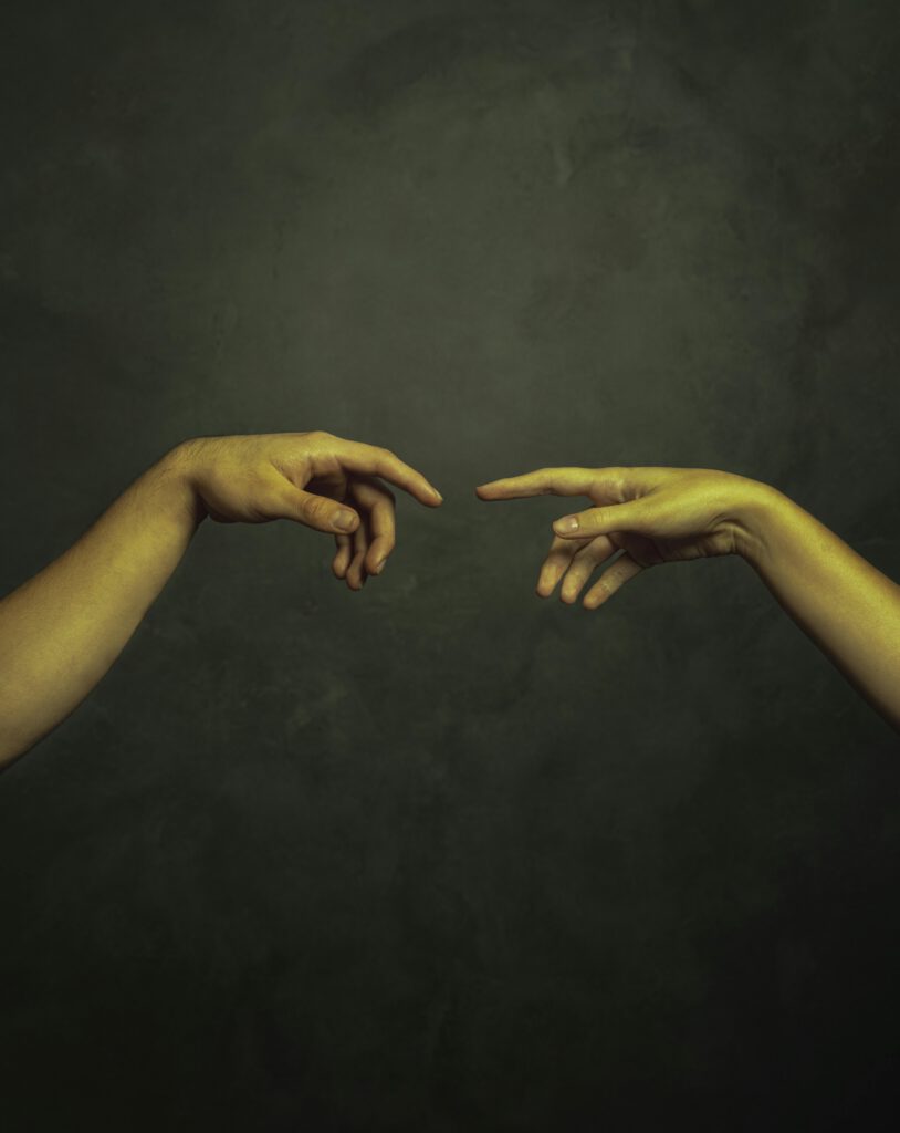 pexels-photo-29256690-29256690 Two hands reaching towards each other against a dark background in an artistic style.