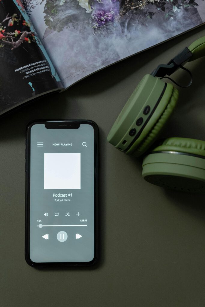 pexels-photo-6686455-6686455 Modern smartphone and green headphones next to a magazine, showcasing technology and lifestyle.